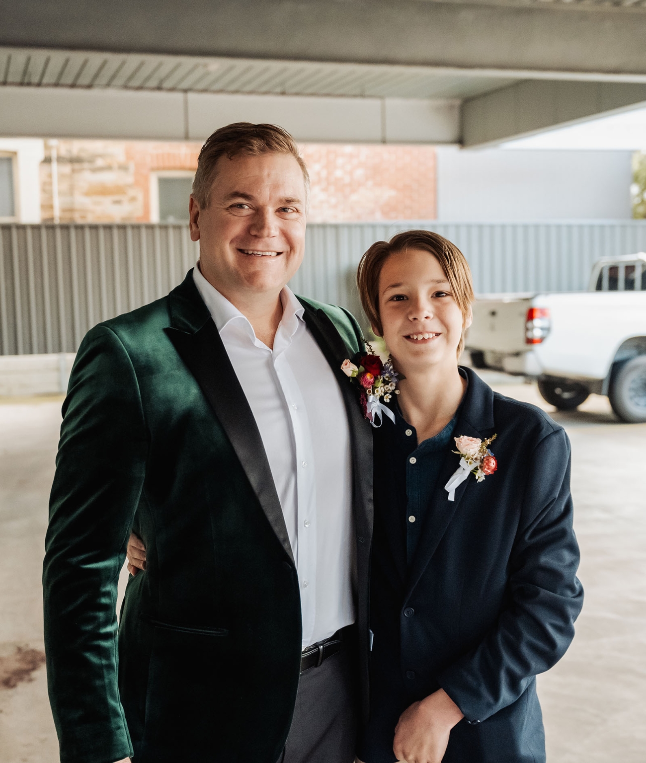 sa marriage office wedding – melissa & kyran 209 Formal man and boy in blazers with matching boutonnieres at outdoor celebration.