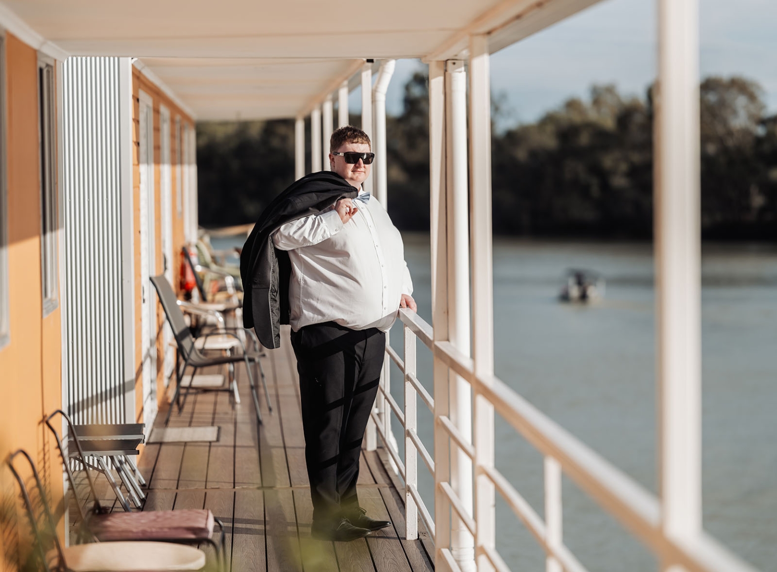 loxton's st peter's church wedding - madeline & brayden 10 Formal man in sunglasses posing on waterfront deck at golden hour.
