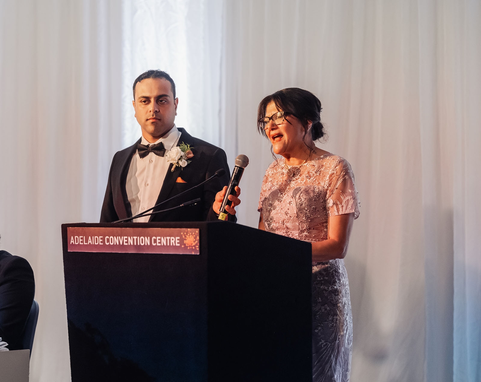 st george & st shenouda coptic church wedding - carmina & bill 85 Wedding speech at Adelaide Convention Centre podium during elegant formal reception.