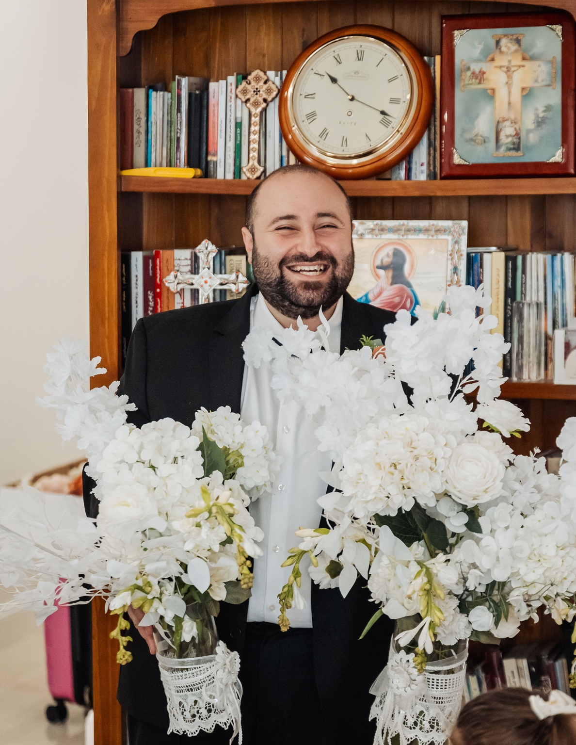st george & st shenouda coptic church wedding - carmina & bill 20 Smiling man in formal suit with white flowers at religious celebration.