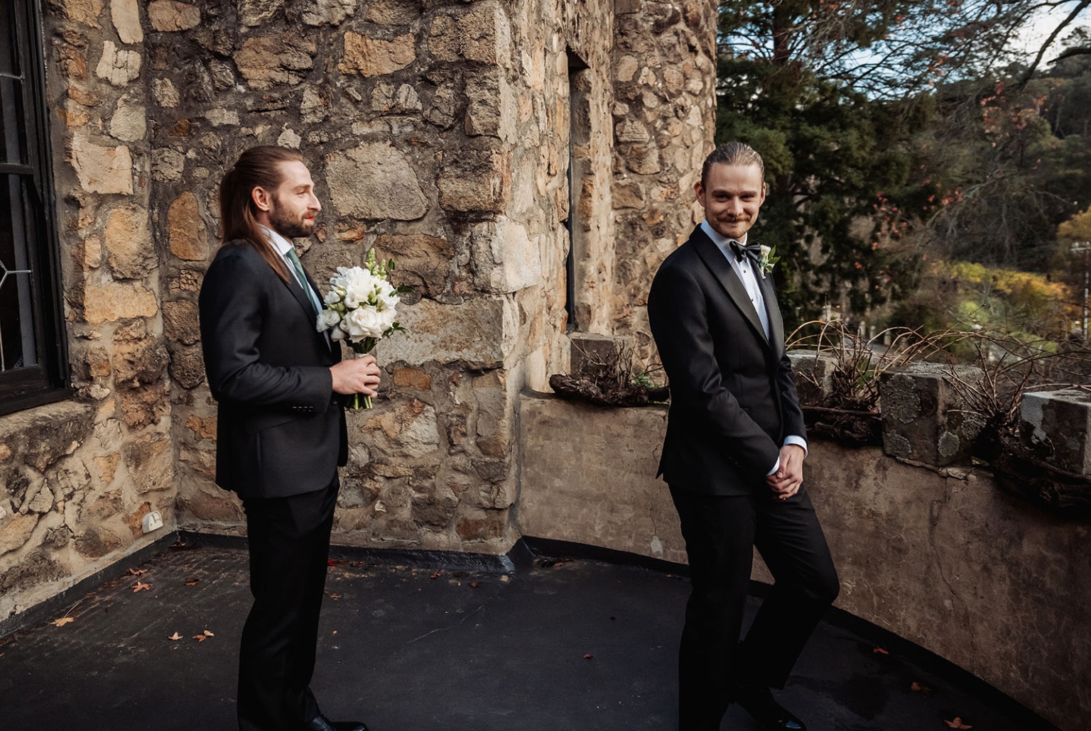 the manor wedding - crystal & mackenzie 33 Elegant wedding portrait of two grooms on rustic stone terrace.