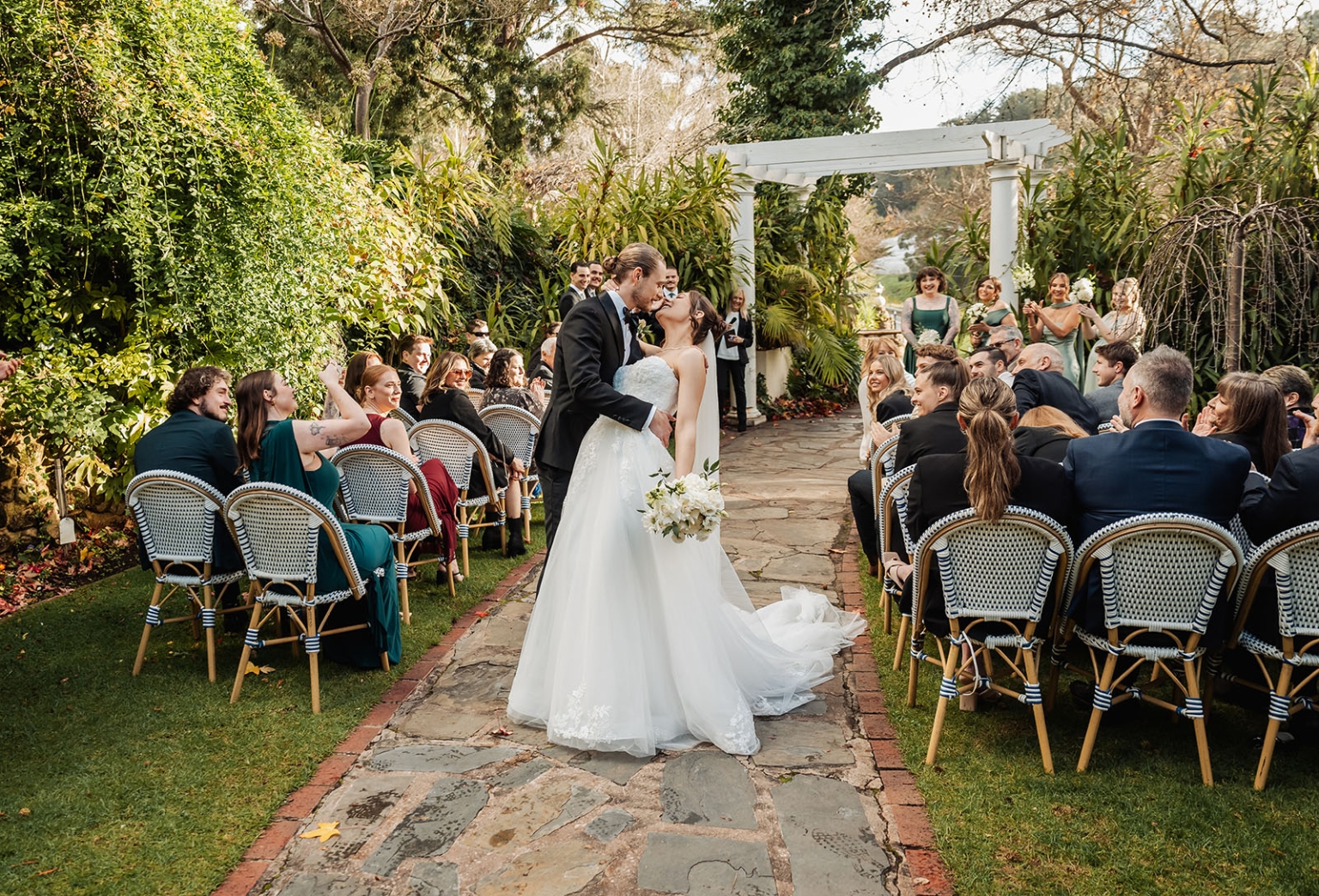 the manor wedding - crystal & mackenzie 60 Bride and groom kiss at outdoor garden wedding ceremony.