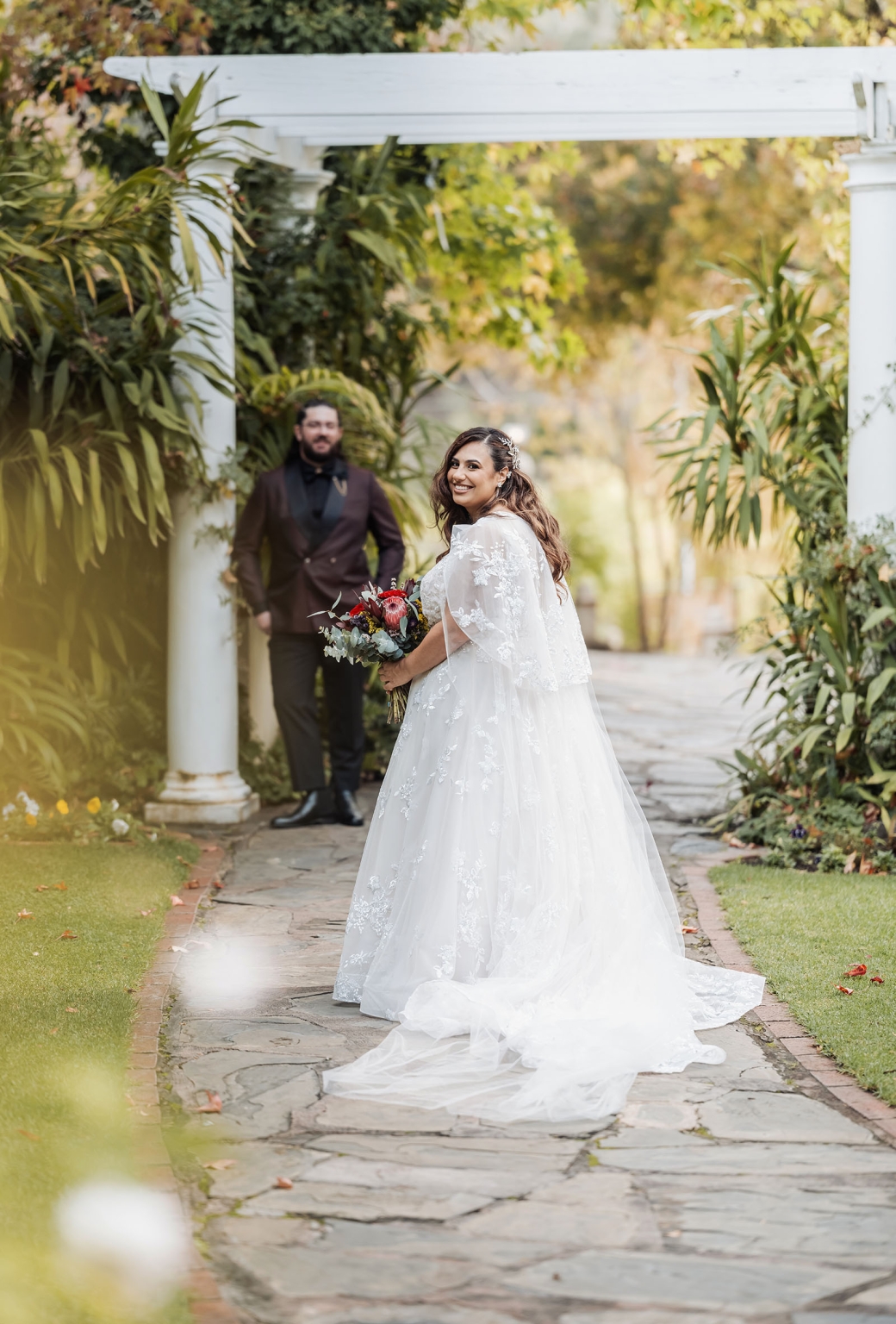 basket range wedding at the manor - leah & wes 32 Garden wedding portrait of bride in lace gown holding bouquet near groom.