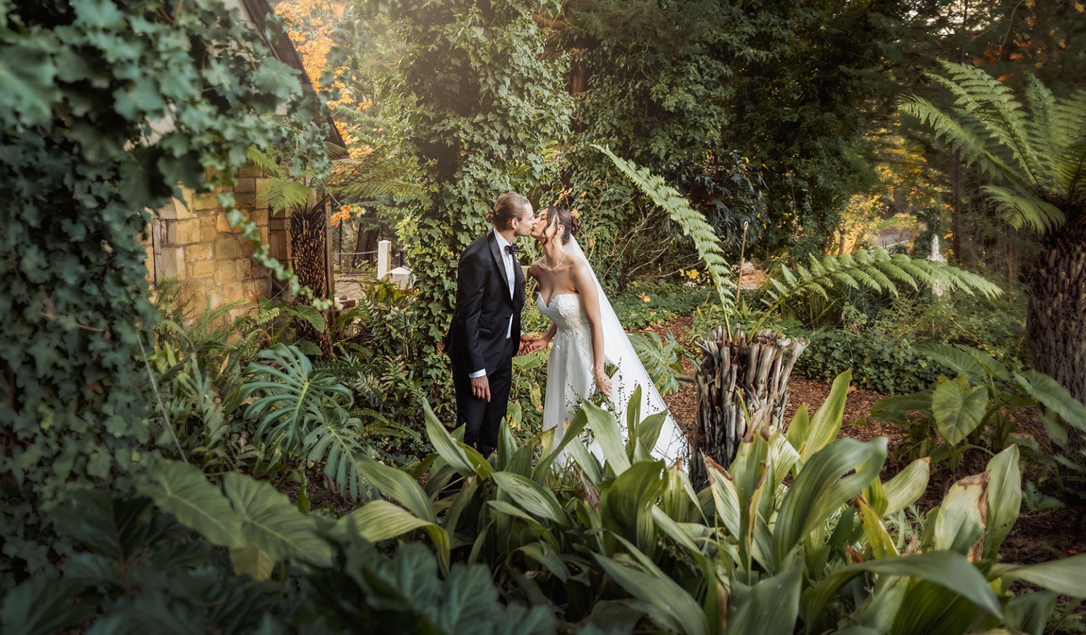 the manor wedding - crystal & mackenzie 66 Romantic bride and groom kiss in lush botanical garden wedding portrait.