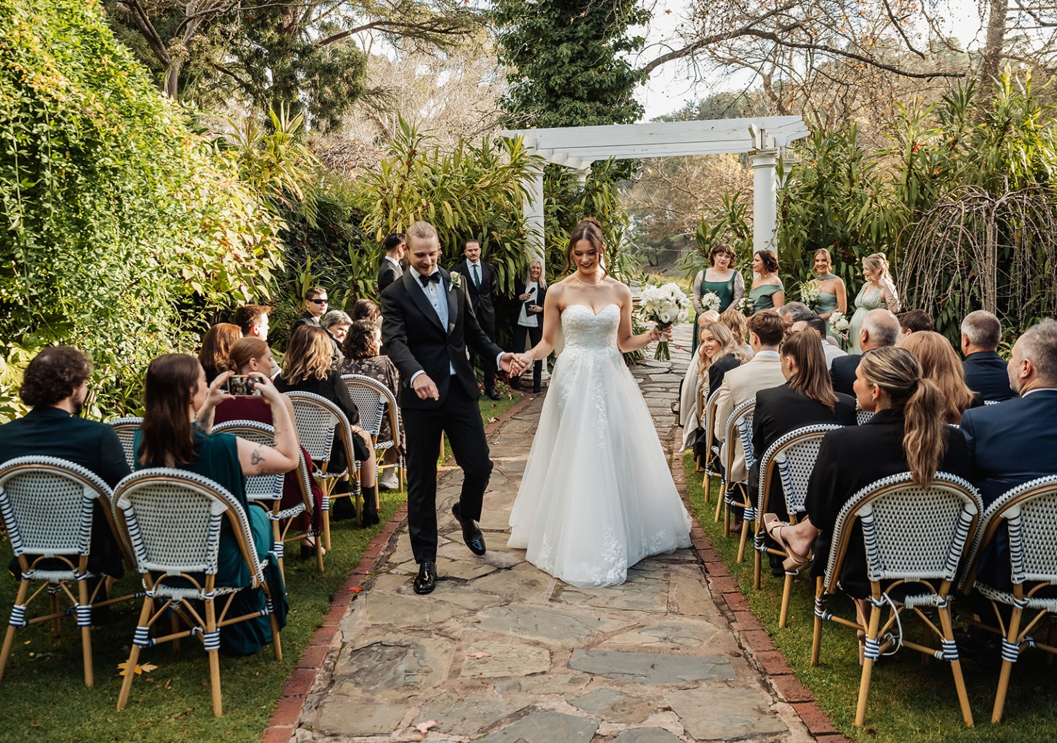 the manor wedding - crystal & mackenzie 59 Bride and groom garden wedding recessional down stone aisle with guests.