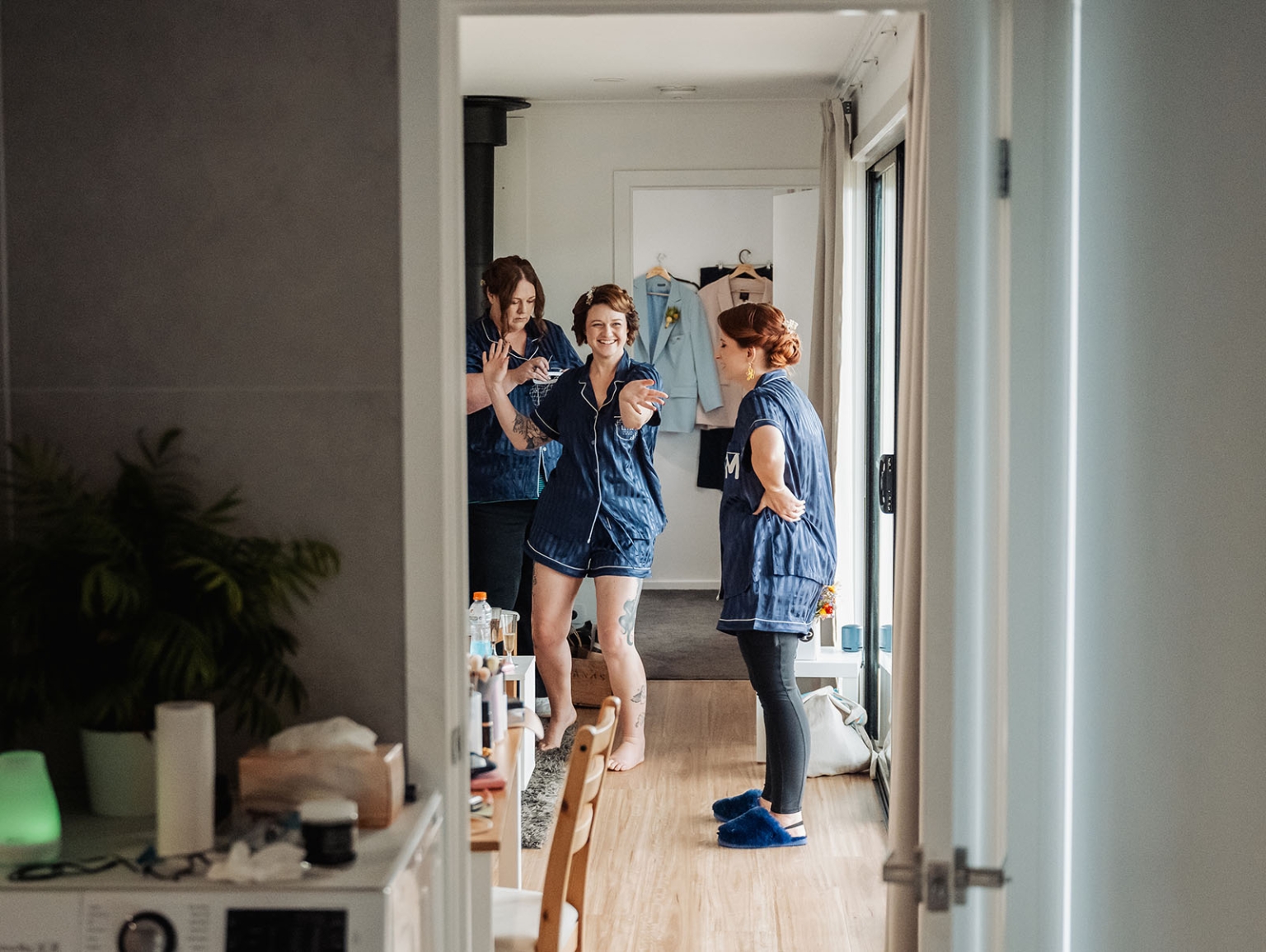 tiny house on the prairie wedding - lauren & bek 3 Bridal party in matching navy pajamas during candid wedding morning getting-ready moment.