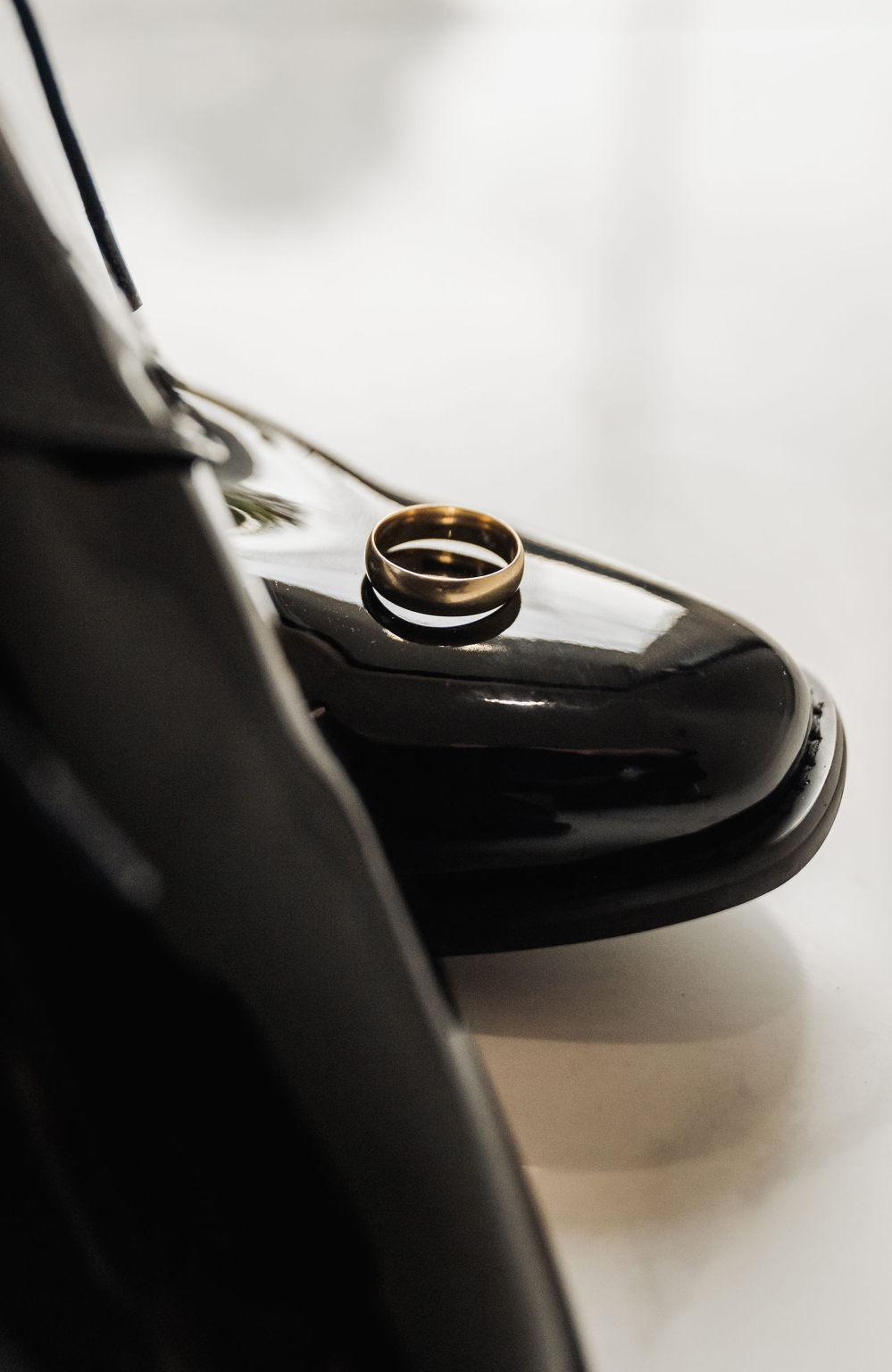 st george & st shenouda coptic church wedding - carmina & bill 3 Gold wedding ring on glossy black dress shoe.