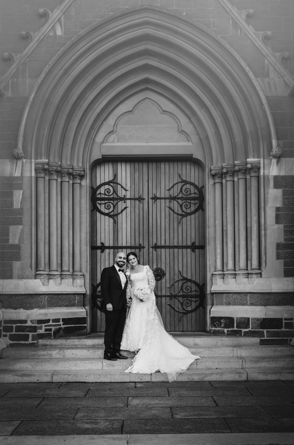 st george & st shenouda coptic church wedding - carmina & bill 69 Gothic church wedding portrait of bride and groom on stone steps.