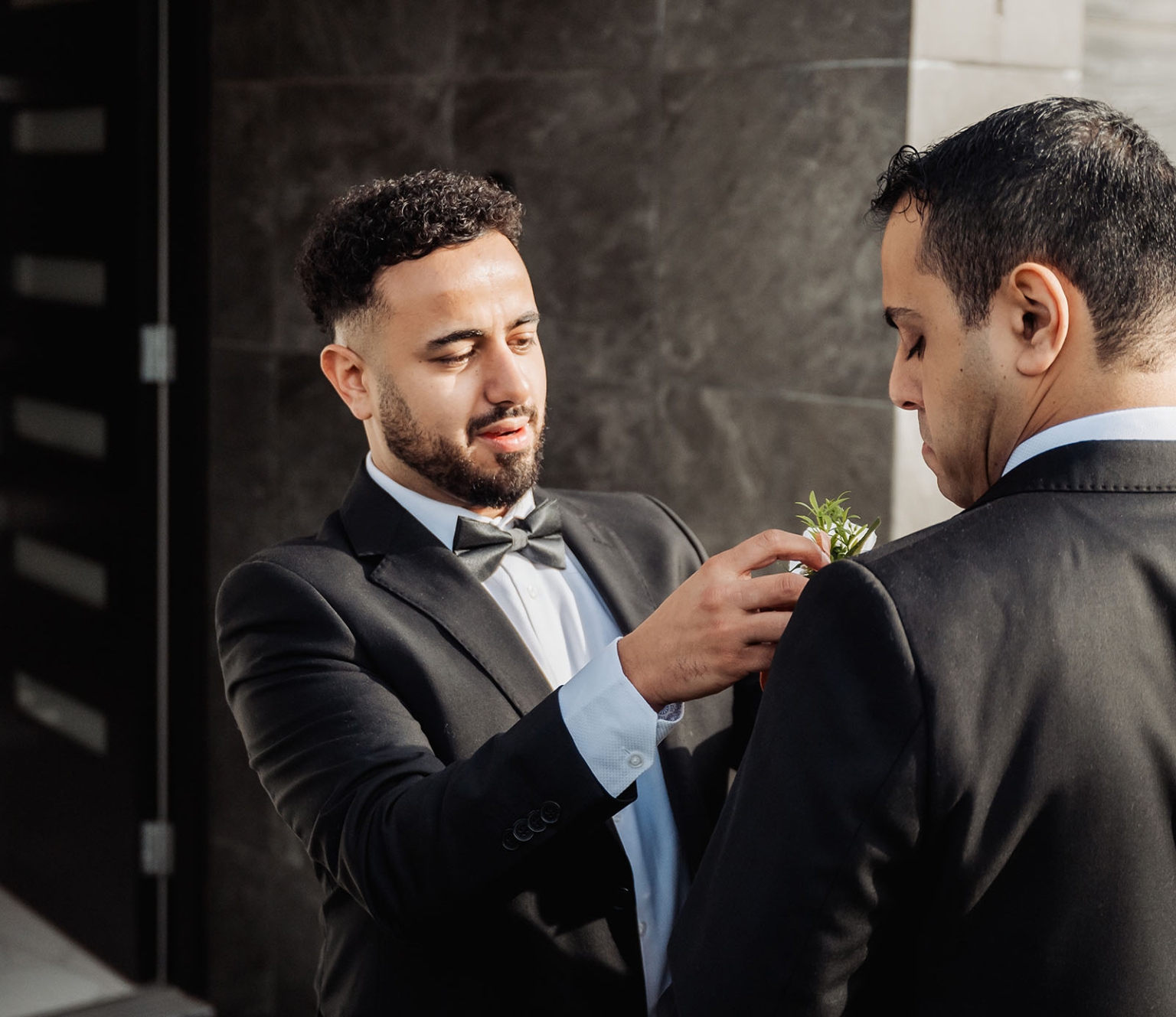 st george & st shenouda coptic church wedding - carmina & bill 10 Groom pins boutonniere on groomsman before wedding ceremony.