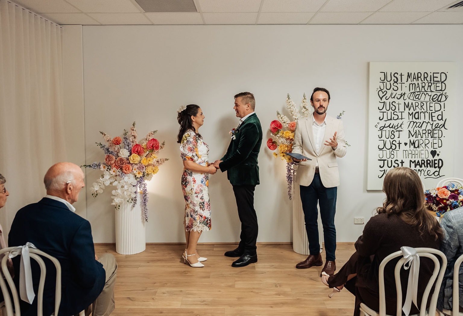 sa marriage office wedding – melissa & kyran 199 SA Marriage Office indoor wedding ceremony with bride, groom, officiant, guests, and colorful floral arrangements.