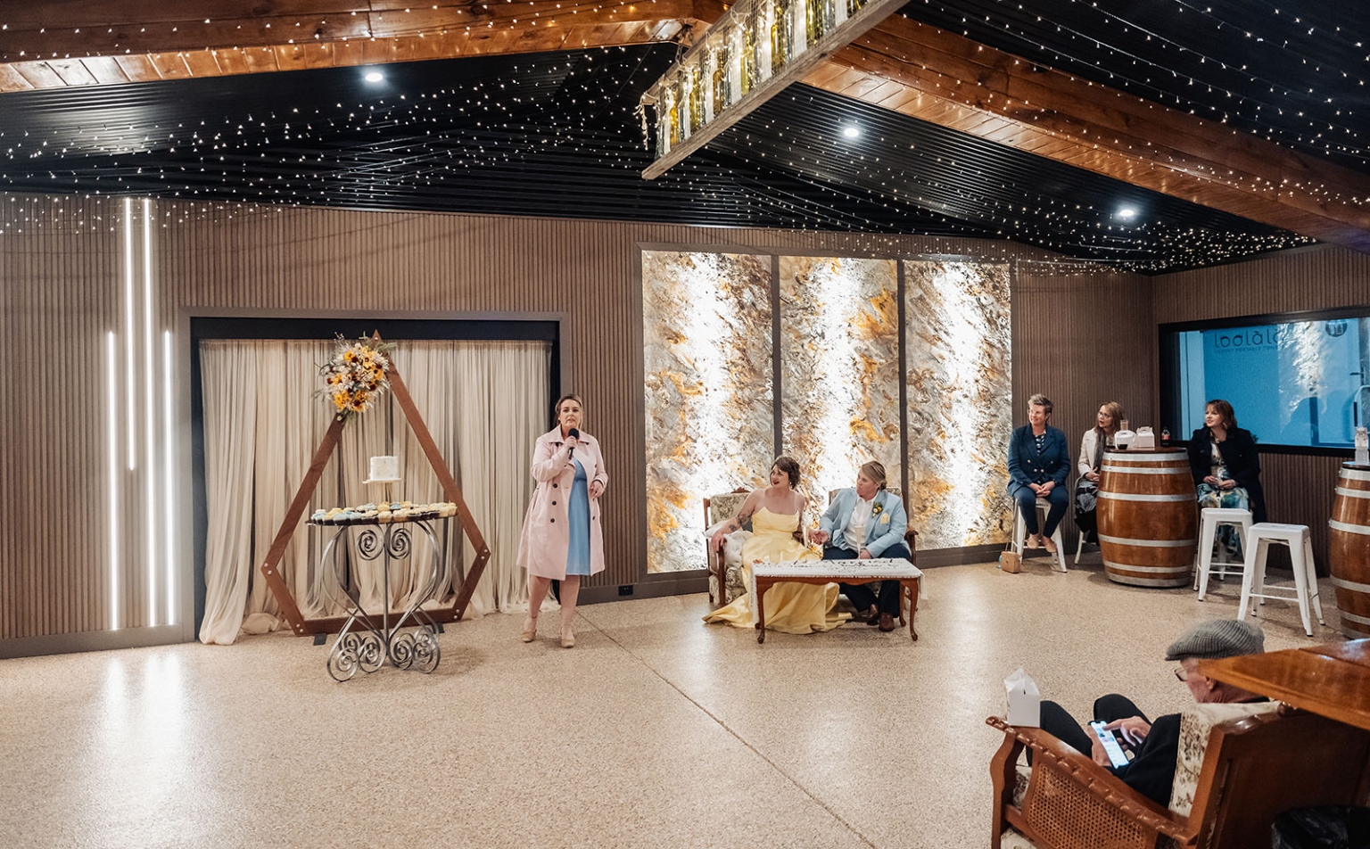 tiny house on the prairie wedding - lauren & bek 62 Rustic indoor wedding venue with string lights, ceremony arch, and reception guests.