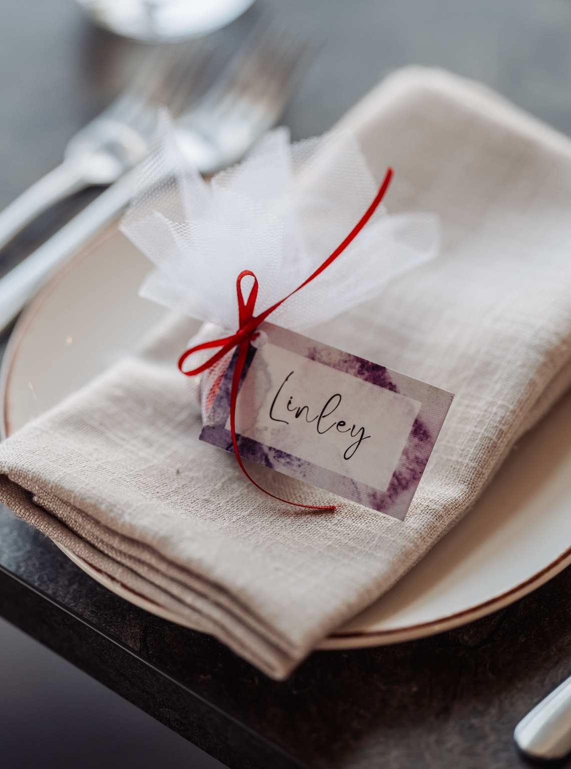 sa marriage office wedding – melissa & kyran 210 Elegant linen napkin place setting with tulle favor, red ribbon, and Linley place card.