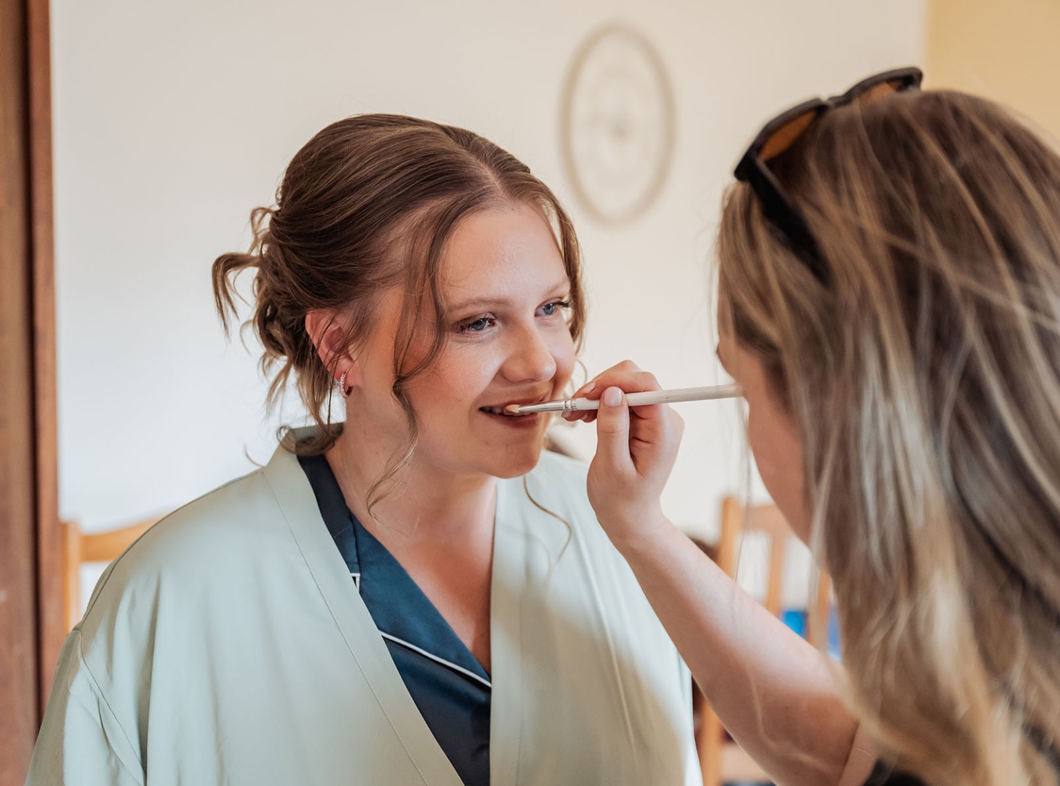 loxton's st peter's church wedding - madeline & brayden 20 Bridal makeup artist applying lipstick to bride during wedding preparation.