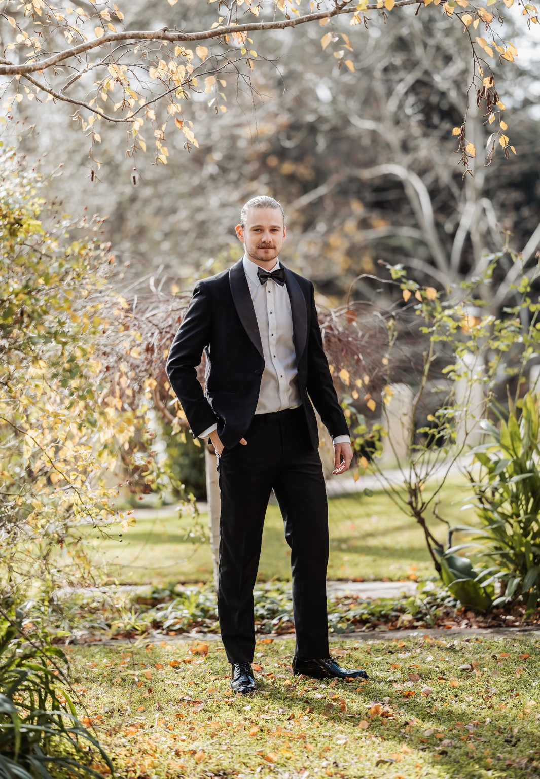 the manor wedding - crystal & mackenzie 6 Elegant man in black tuxedo posing in autumn garden portrait.