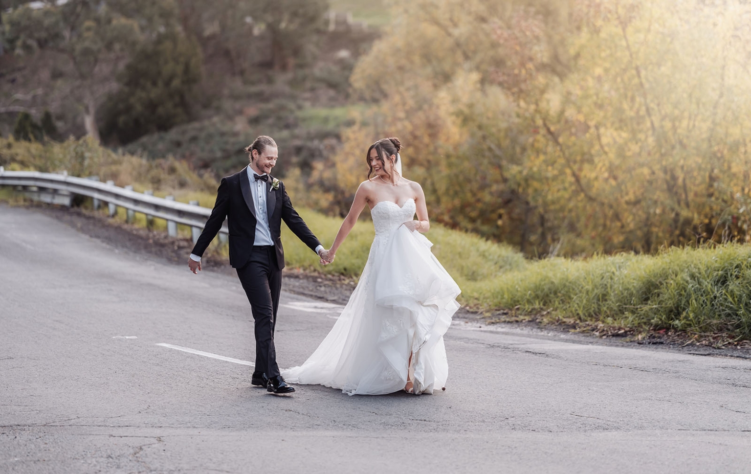 the manor wedding - crystal & mackenzie 79 Newlywed bride and groom walking hand in hand on a romantic country road.