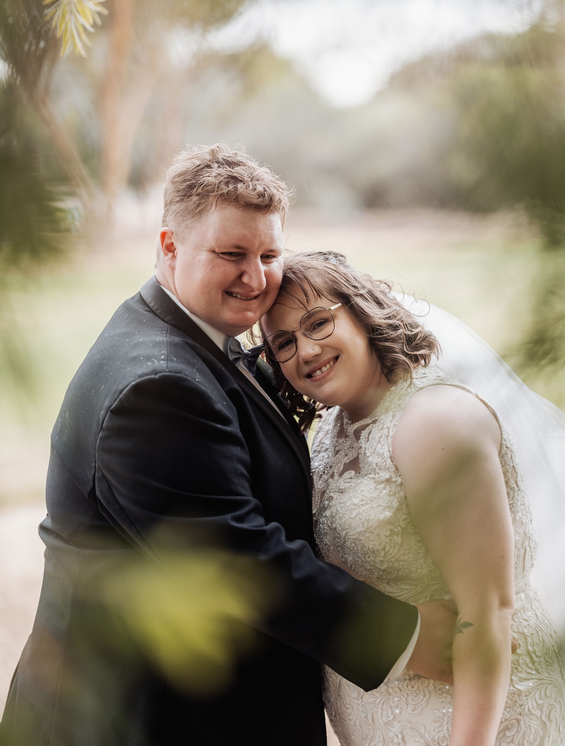 loxton's st peter's church wedding - madeline & brayden 50 Smiling newlywed couple in elegant wedding attire during an outdoor garden portrait.