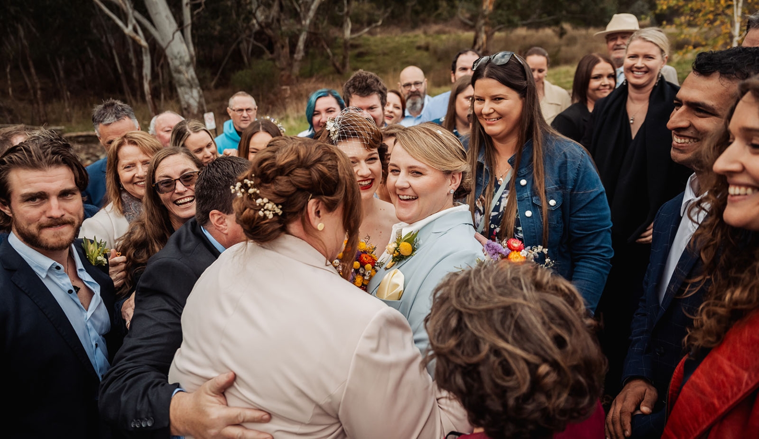 tiny house on the prairie wedding - lauren & bek 36 Joyful outdoor wedding guests celebrate brides in rustic woodland ceremony.