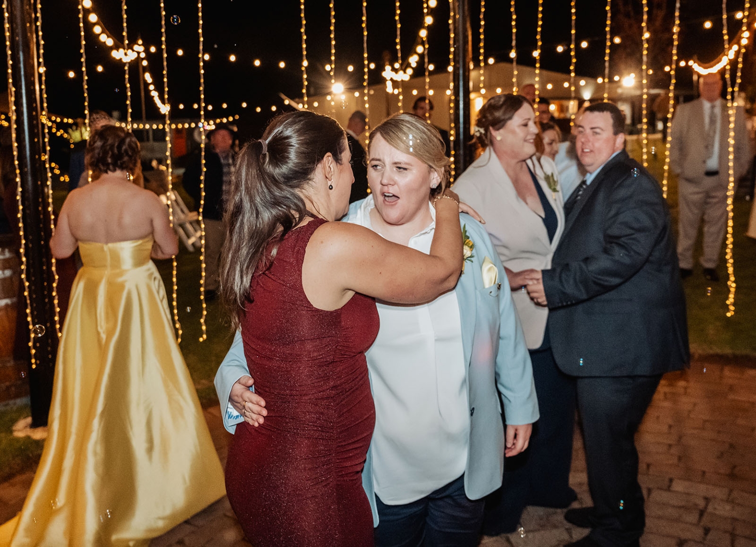 tiny house on the prairie wedding - lauren & bek 66 Outdoor wedding reception guests dancing under romantic string lights at night.