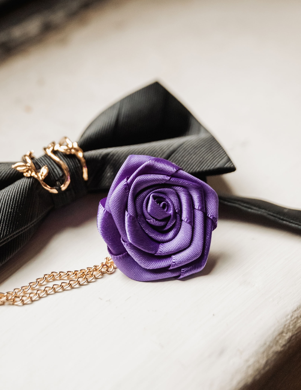 basket range wedding at the manor - leah & wes 17 Purple satin rose with black grosgrain bow and gold chain jewelry.
