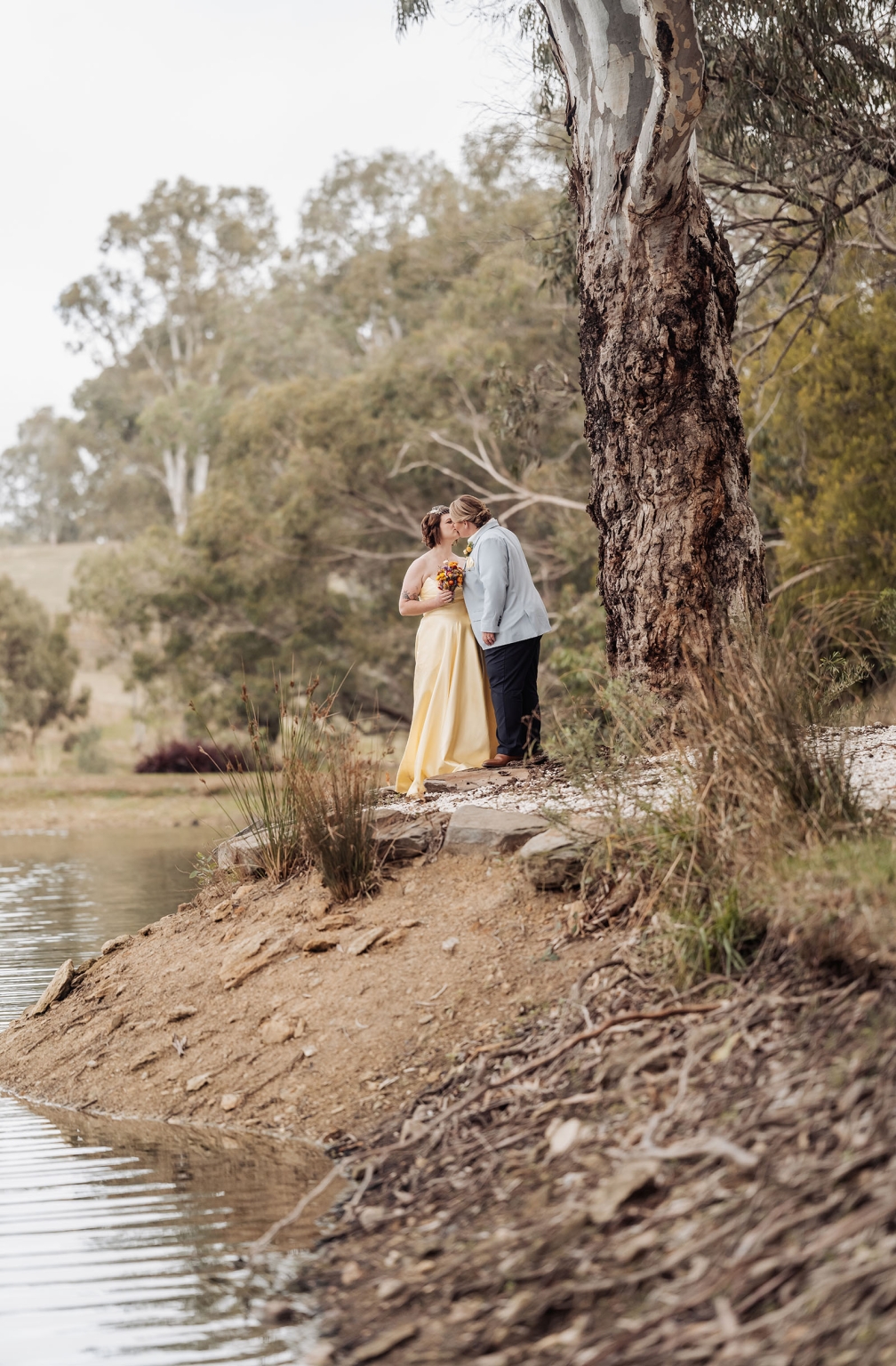 tiny house on the prairie wedding - lauren & bek 44 Riverside wedding portrait of couple kissing under a tree.