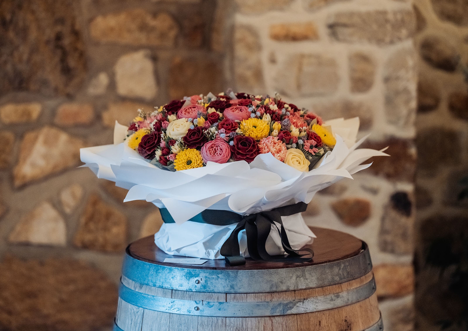 basket range wedding at the manor - leah & wes 67 Rustic luxury flower bouquet with roses on a wooden barrel.