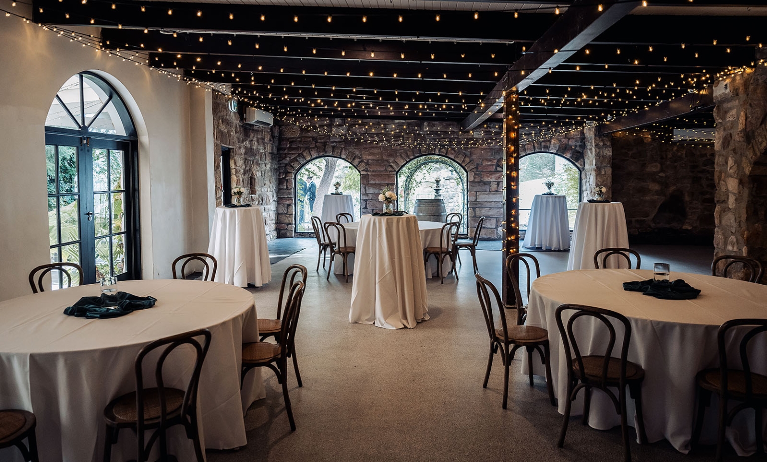 the manor wedding - crystal & mackenzie 86 Rustic stone wedding venue with string lights and elegant banquet tables.