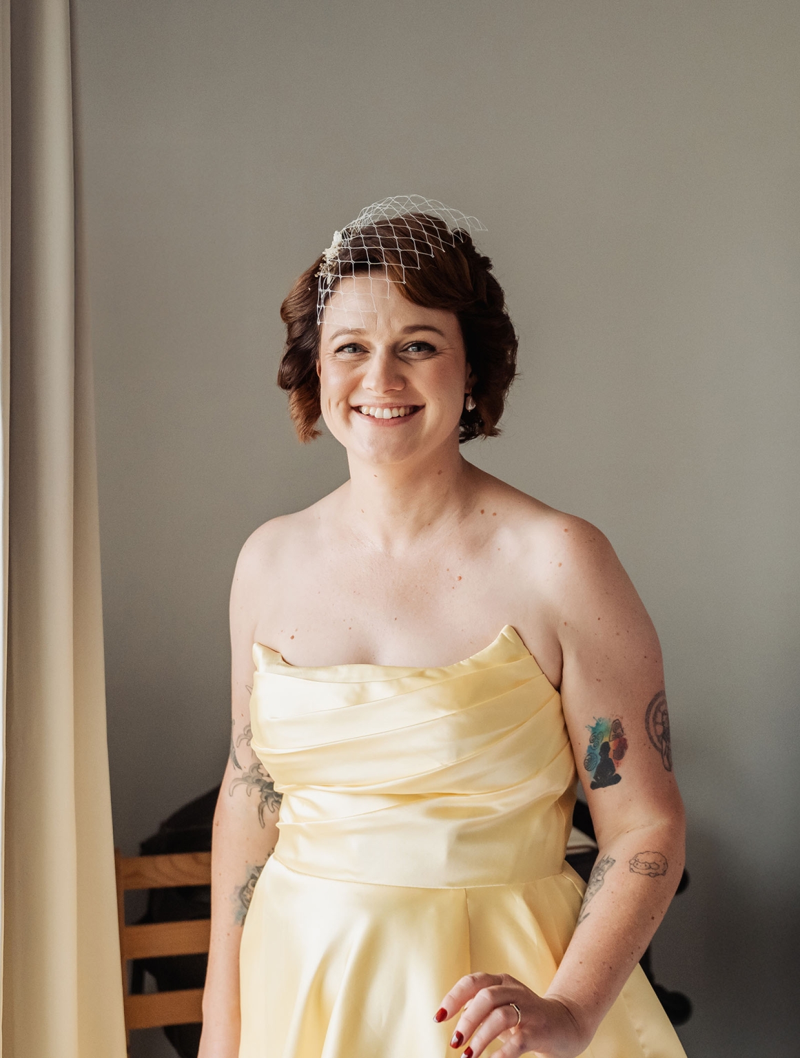 tiny house on the prairie wedding - lauren & bek 9 Smiling bride in yellow strapless dress with birdcage veil and tattoos.
