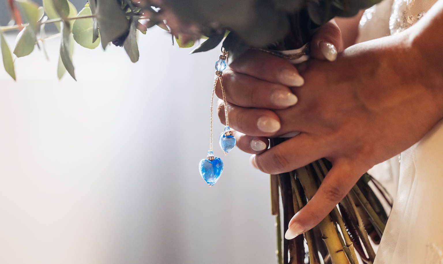 basket range wedding at the manor - leah & wes 12 Bride holding wedding bouquet with blue heart charms.