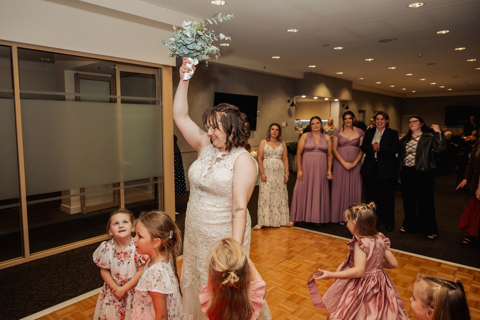 how to create a wedding qr code to collect photos 15 Bride raises bouquet for toss on wedding reception dance floor with flower girls.