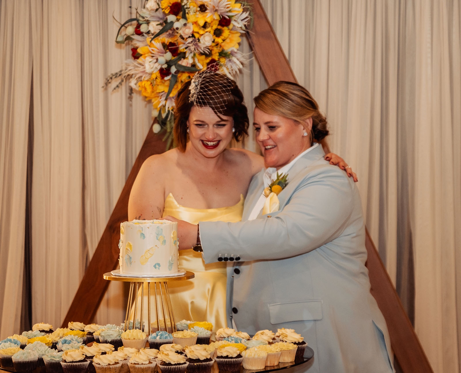 tiny house on the prairie wedding - lauren & bek 63 Lesbian brides cutting wedding cake at romantic reception.