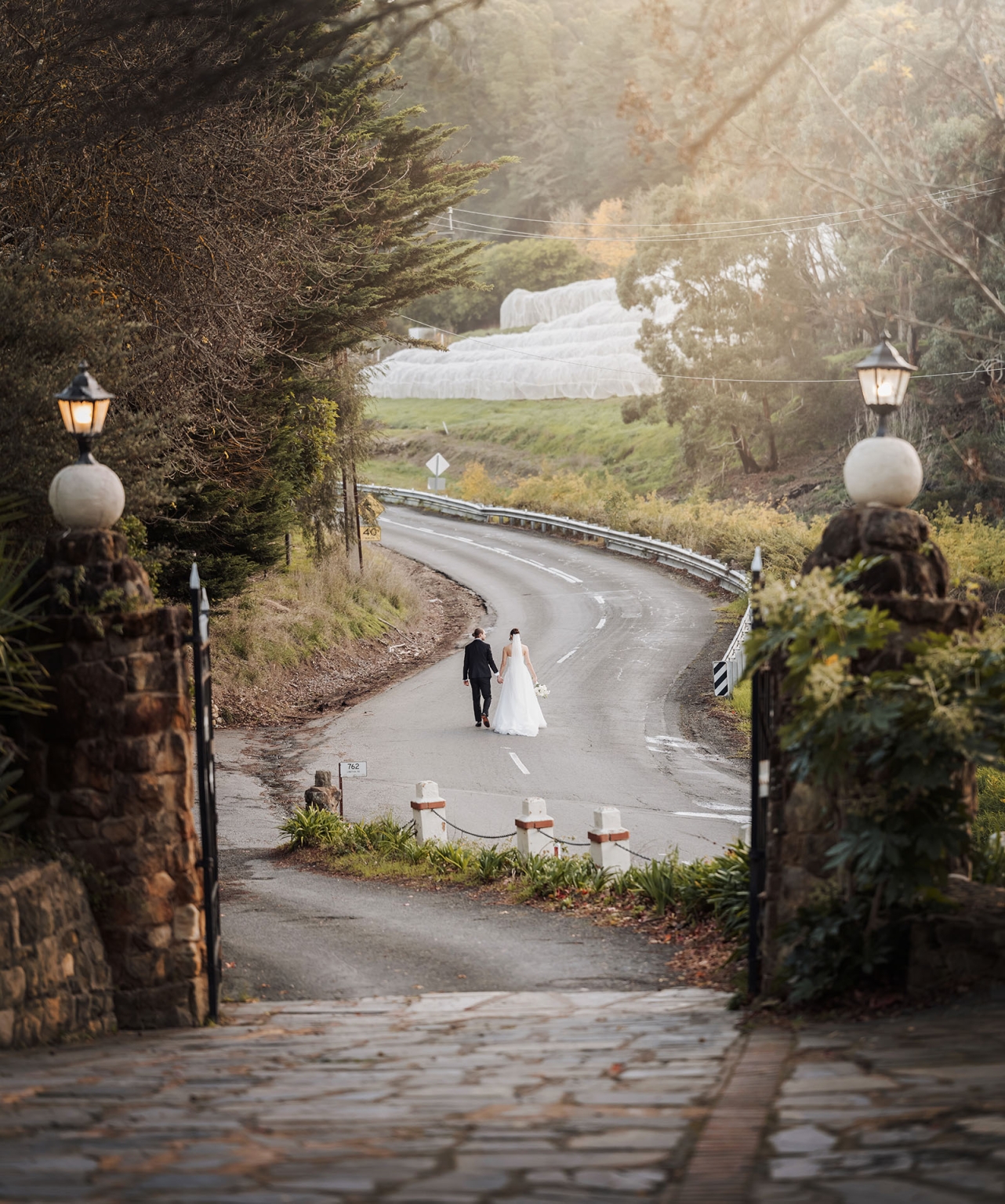 the manor wedding - crystal & mackenzie 78 Bride and groom walking along romantic countryside road after wedding.