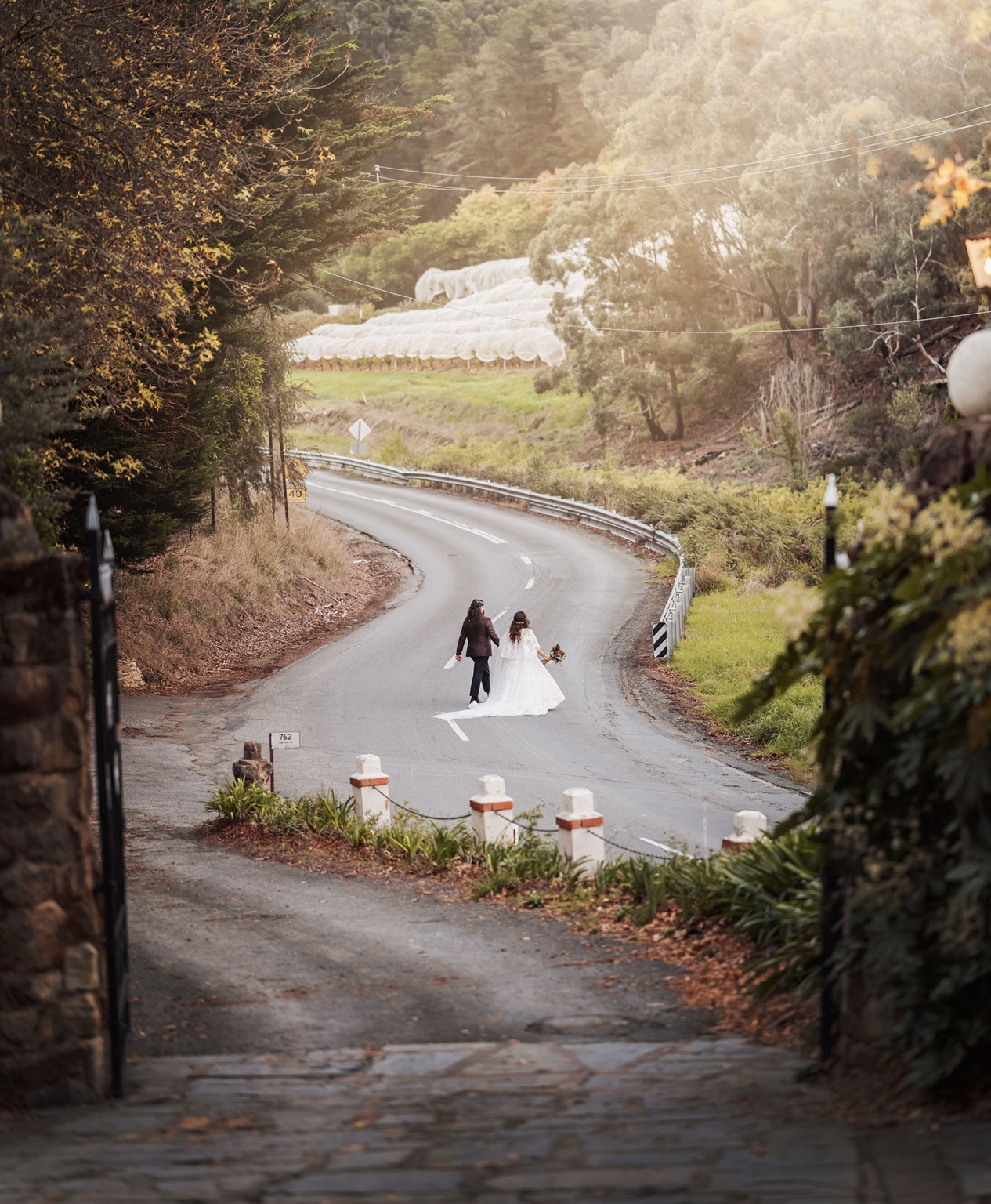 basket range wedding at the manor - leah & wes 54 Wedding bride and groom walking hand in hand on a scenic country road.