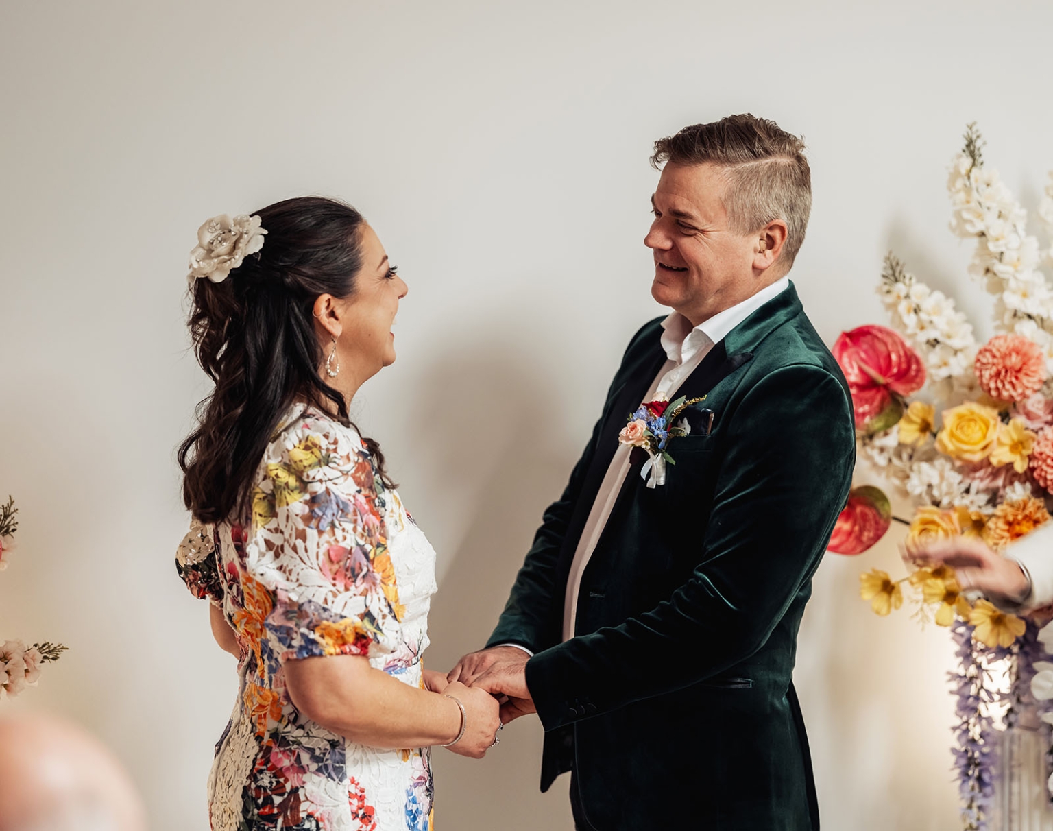 sa marriage office wedding – melissa & kyran 195 Wedding couple holding hands during colorful floral ceremony.