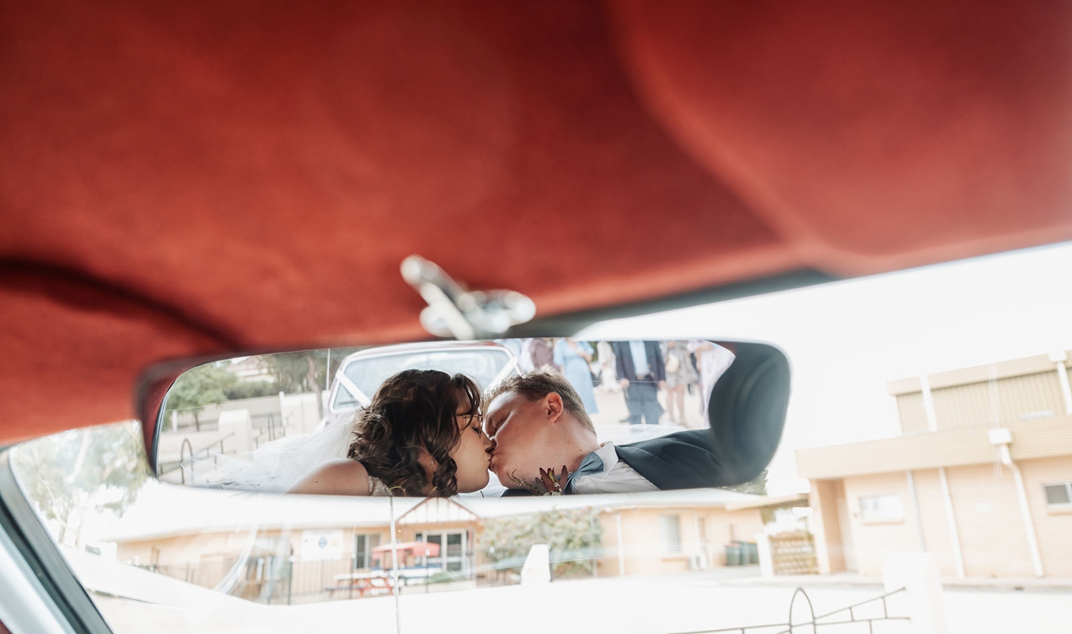 loxton's st peter's church wedding - madeline & brayden 43 Wedding bride and groom kissing in a car rearview mirror.