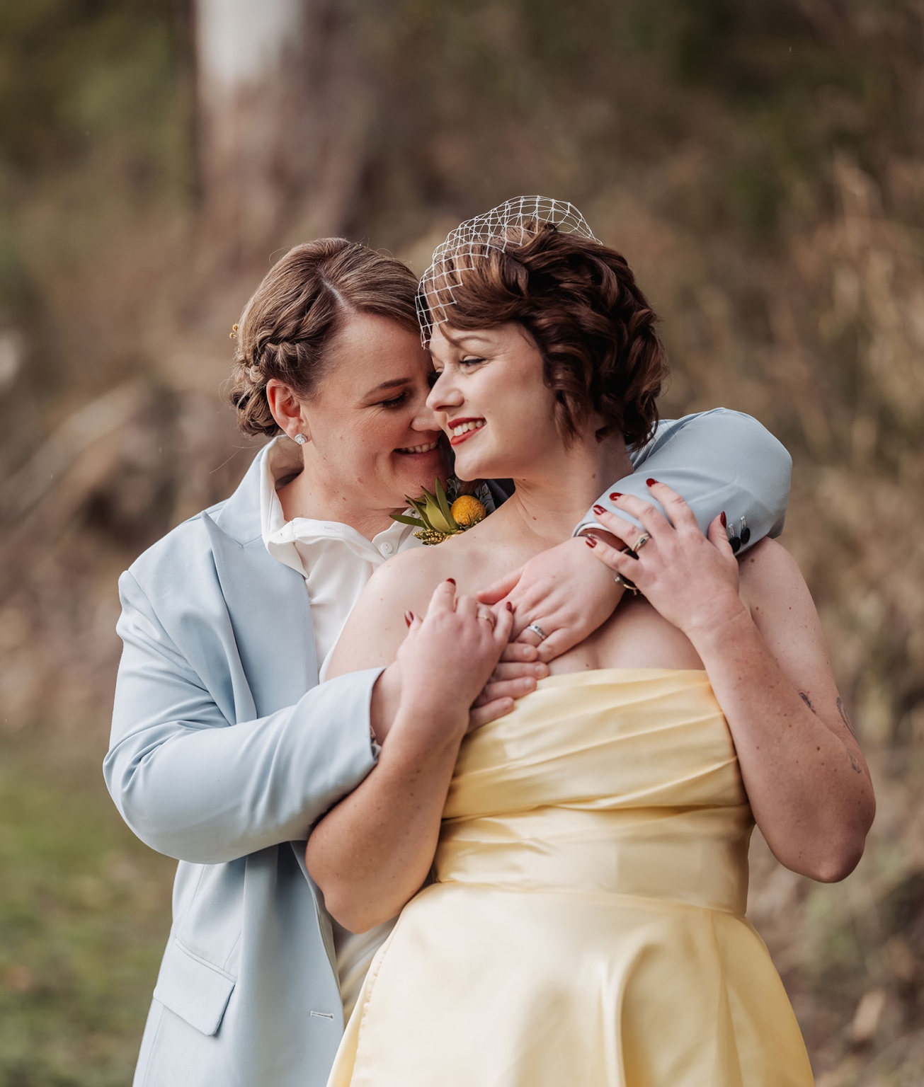 tiny house on the prairie wedding - lauren & bek 49 Joyful wedding couple embracing outdoors in elegant blue suit and yellow gown.
