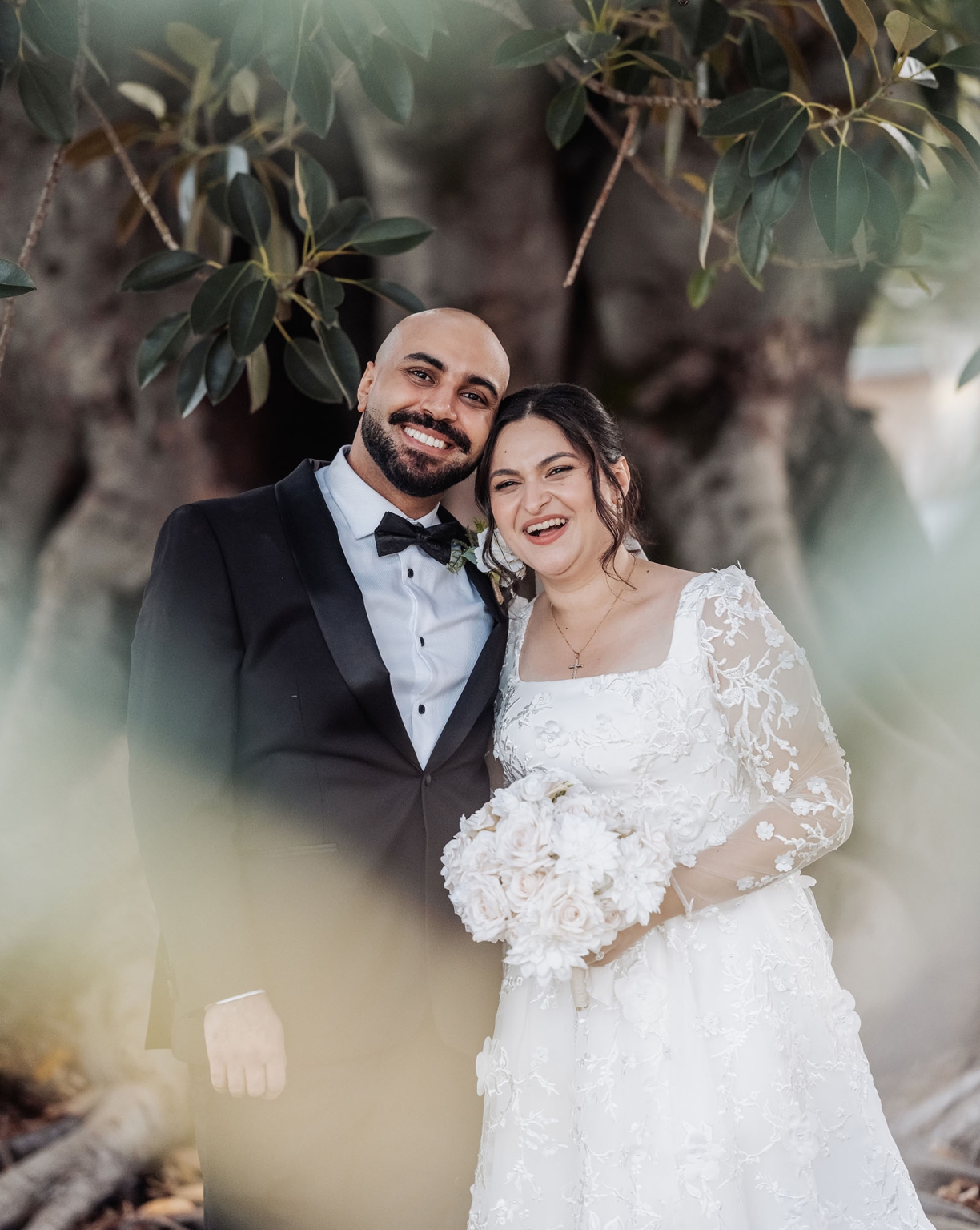 st george & st shenouda coptic church wedding - carmina & bill 73 Joyful bride and groom wedding portrait in garden with bouquet and tuxedo.