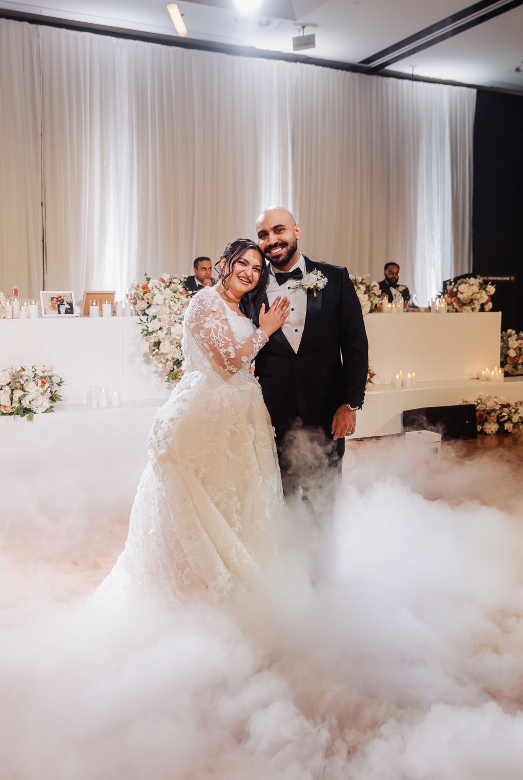st george & st shenouda coptic church wedding - carmina & bill 94 Joyful bride and groom wedding reception portrait with floral decor and romantic fog.