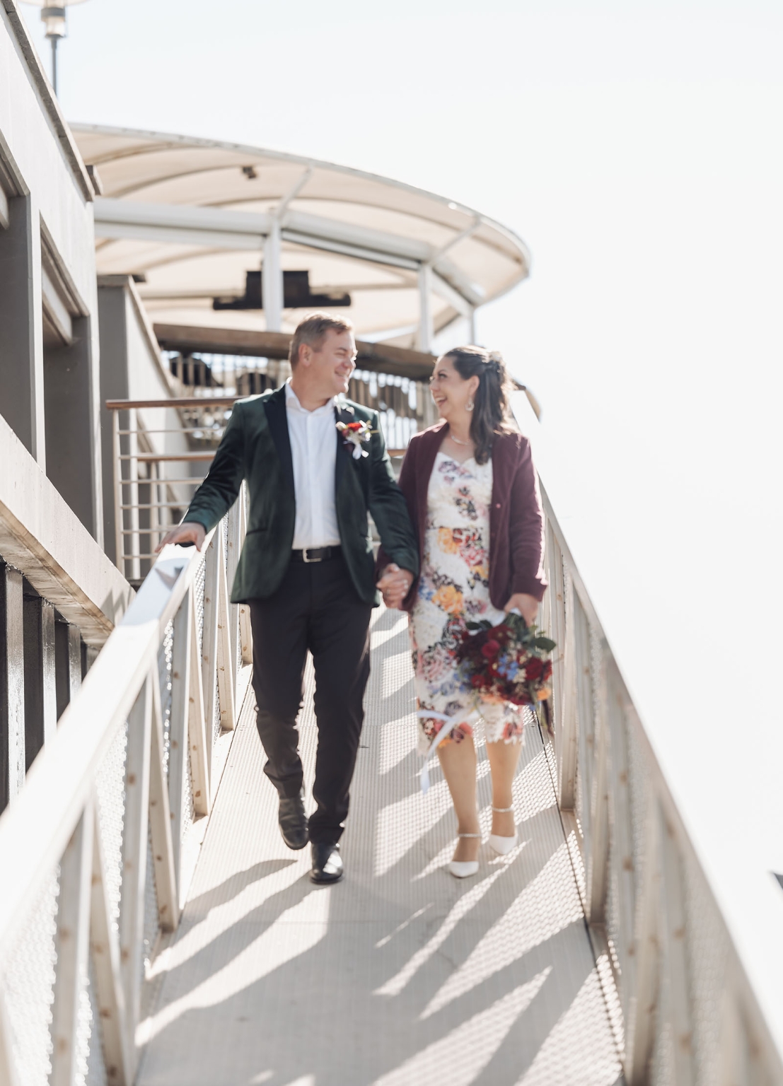 sa marriage office wedding – melissa & kyran 215 Wedding couple holding hands walking on sunny urban ramp with bouquet.