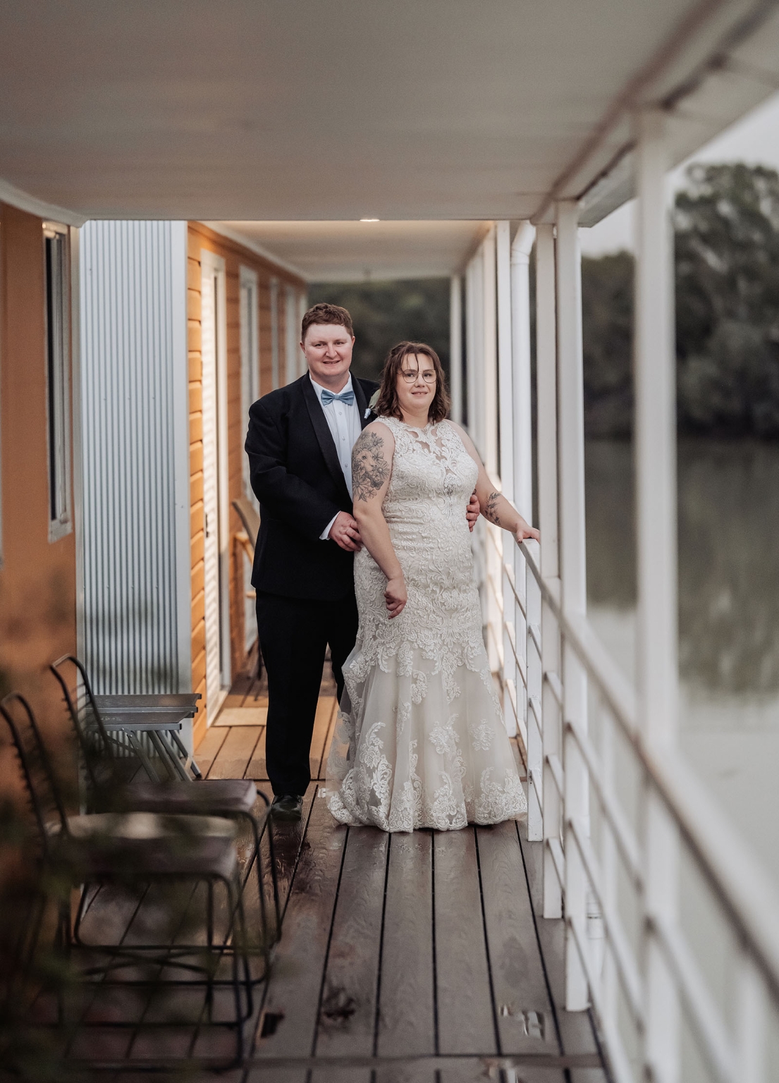 loxton's st peter's church wedding - madeline & brayden 74 Newlywed couple in wedding attire posing on a rustic wooden porch.