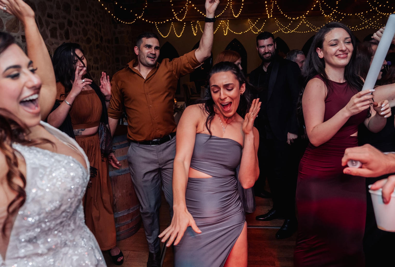basket range wedding at the manor - leah & wes 77 Wedding guests dancing on a lively reception dance floor under warm string lights.