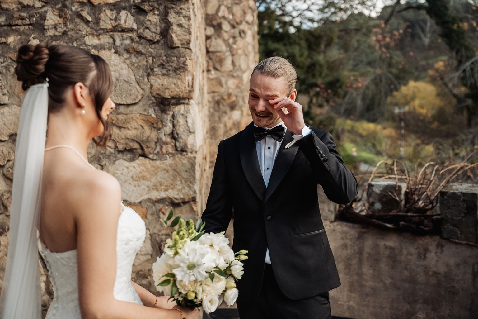 the manor wedding - crystal & mackenzie 42 Emotional wedding first look beside rustic stone wall with bride and groom.