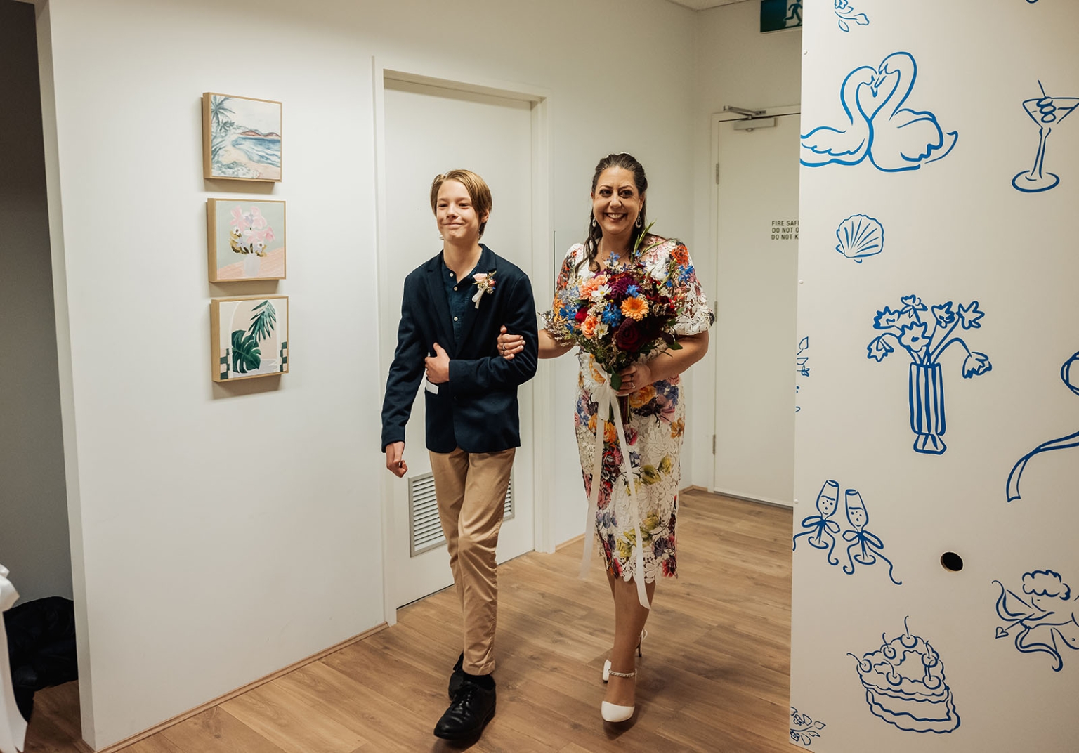 sa marriage office wedding – melissa & kyran 196 Woman and young escort enter wedding venue hallway with colorful wedding bouquet.