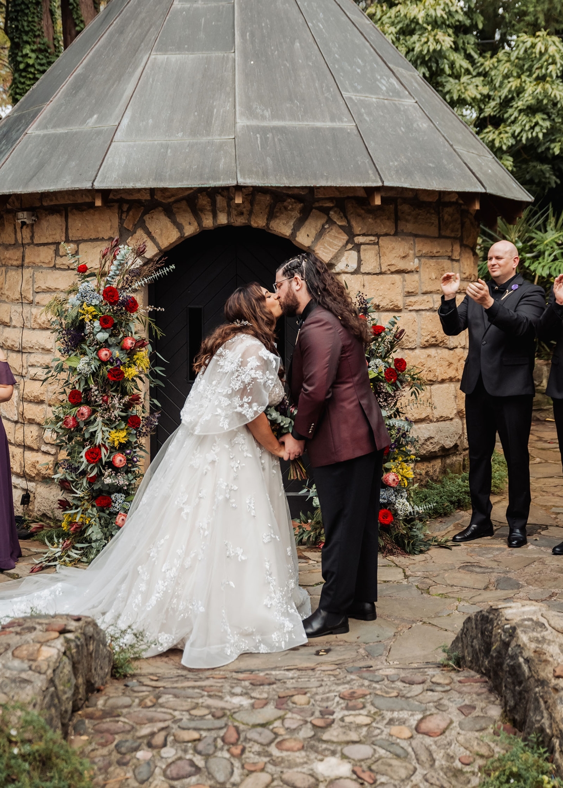 basket range wedding at the manor - leah & wes 52 Bride and groom kiss at rustic stone chapel garden wedding ceremony.