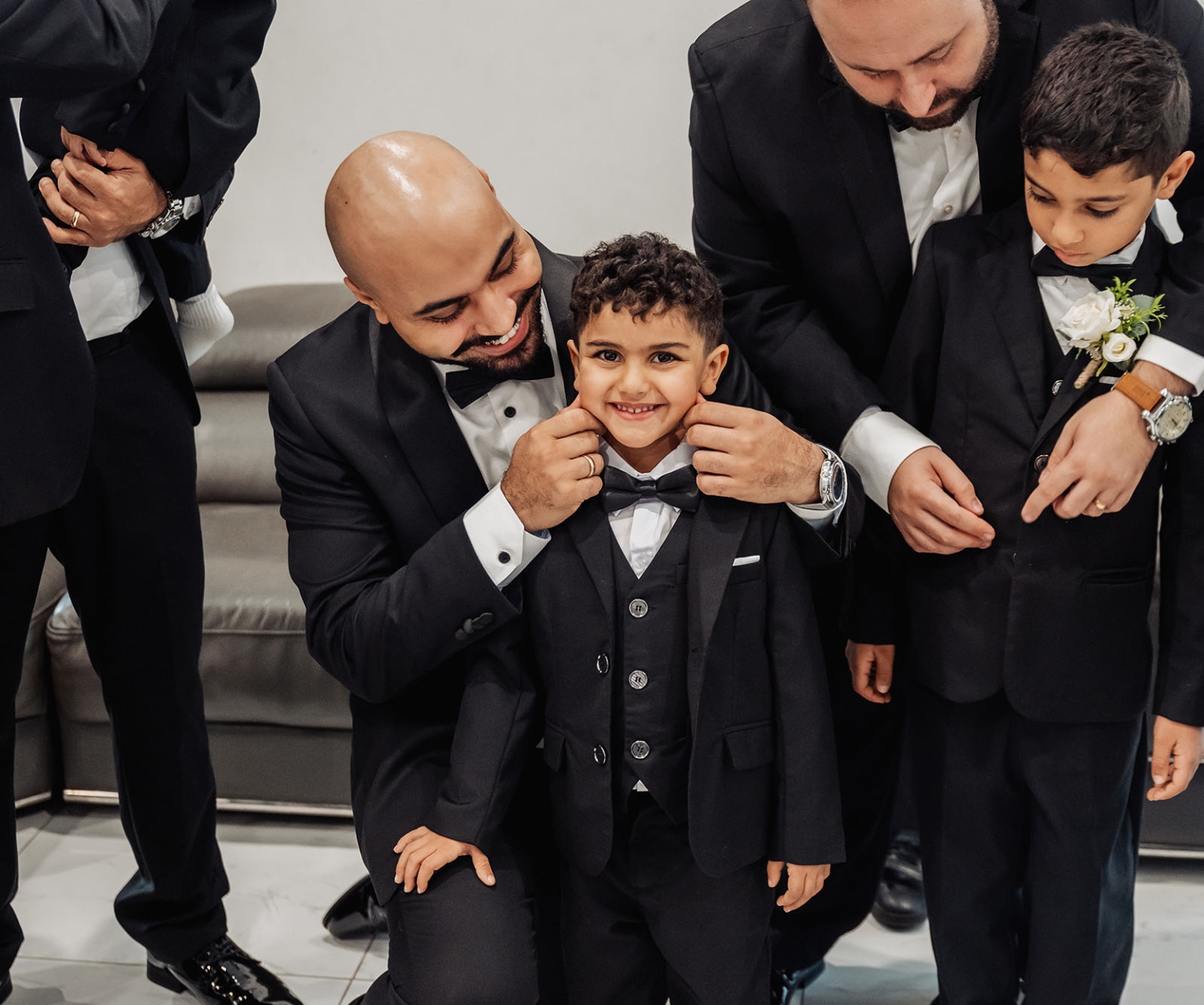 st george & st shenouda coptic church wedding - carmina & bill 9 Groomsmen help young ring bearers prepare in black tuxedos for a wedding.
