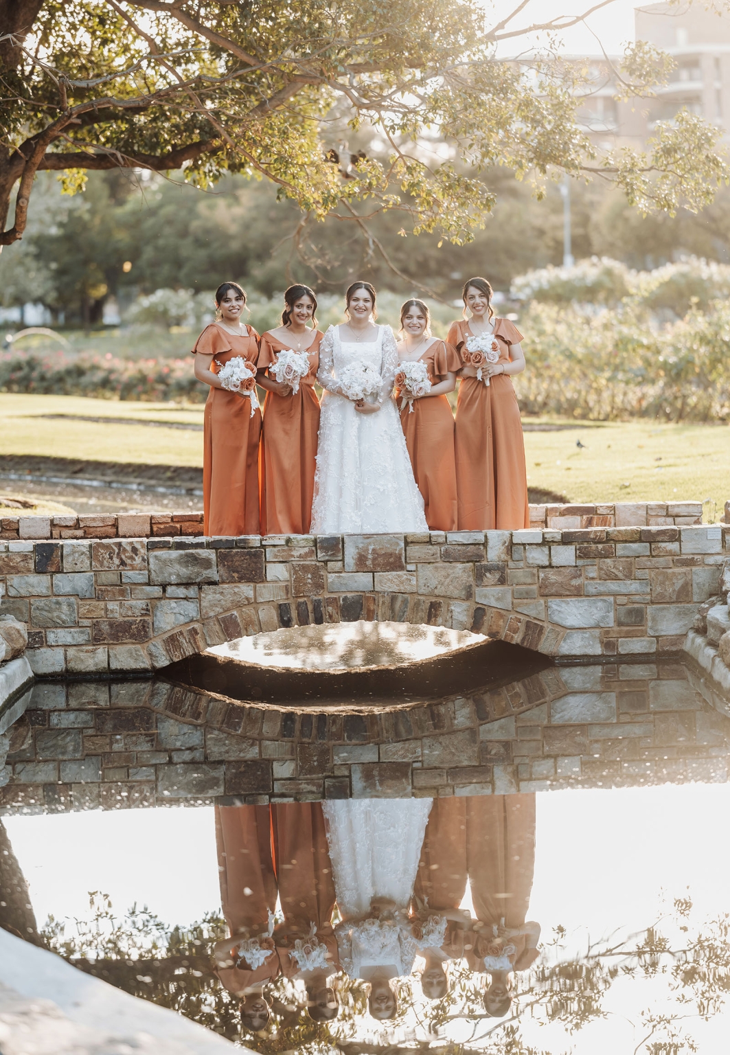 st george & st shenouda coptic church wedding - carmina & bill 63 Bride and bridesmaids in rust dresses on stone bridge wedding portrait.