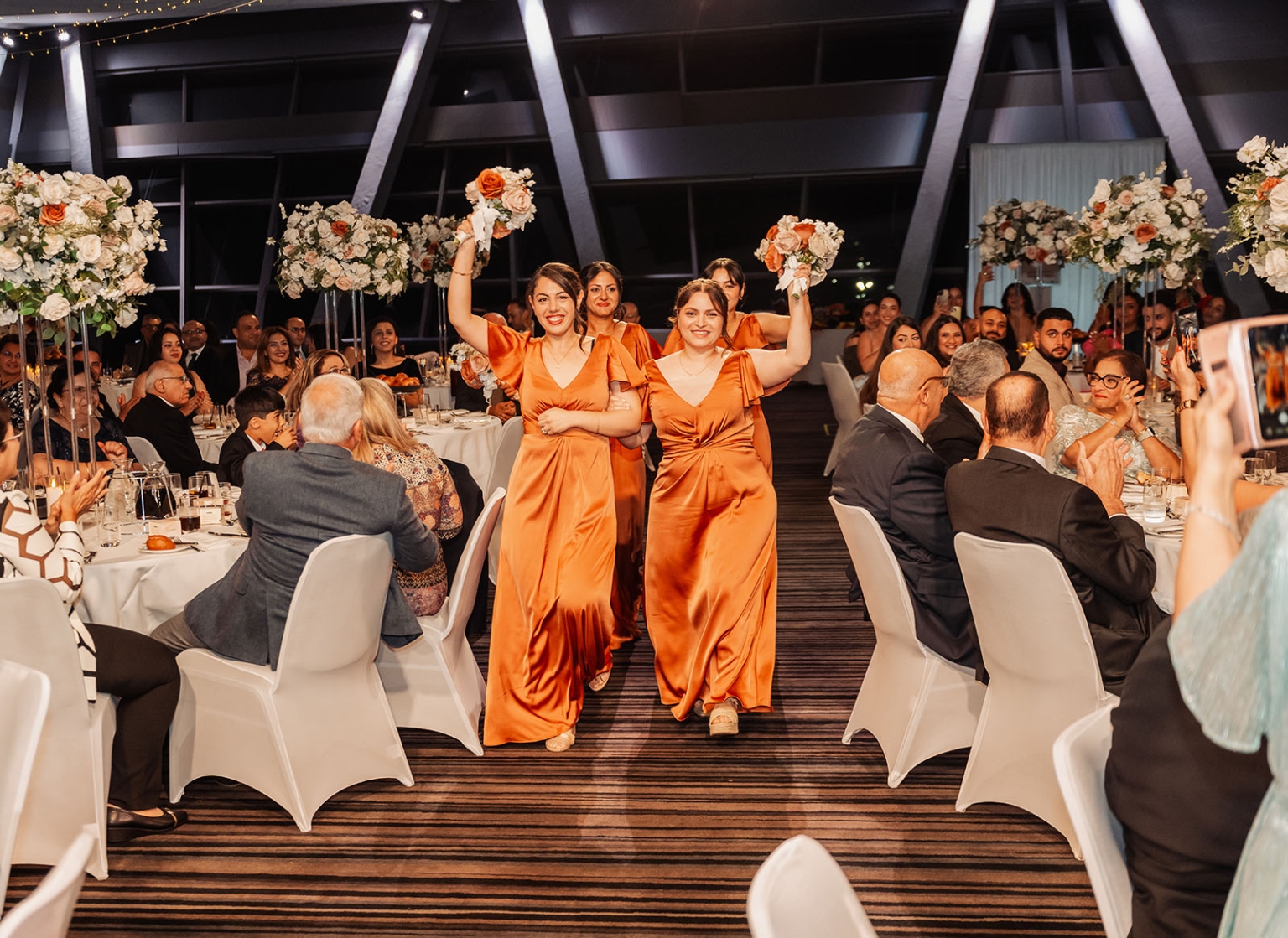 st george & st shenouda coptic church wedding - carmina & bill 82 Bridesmaids make joyful entrance at elegant wedding reception in burnt-orange satin gowns.