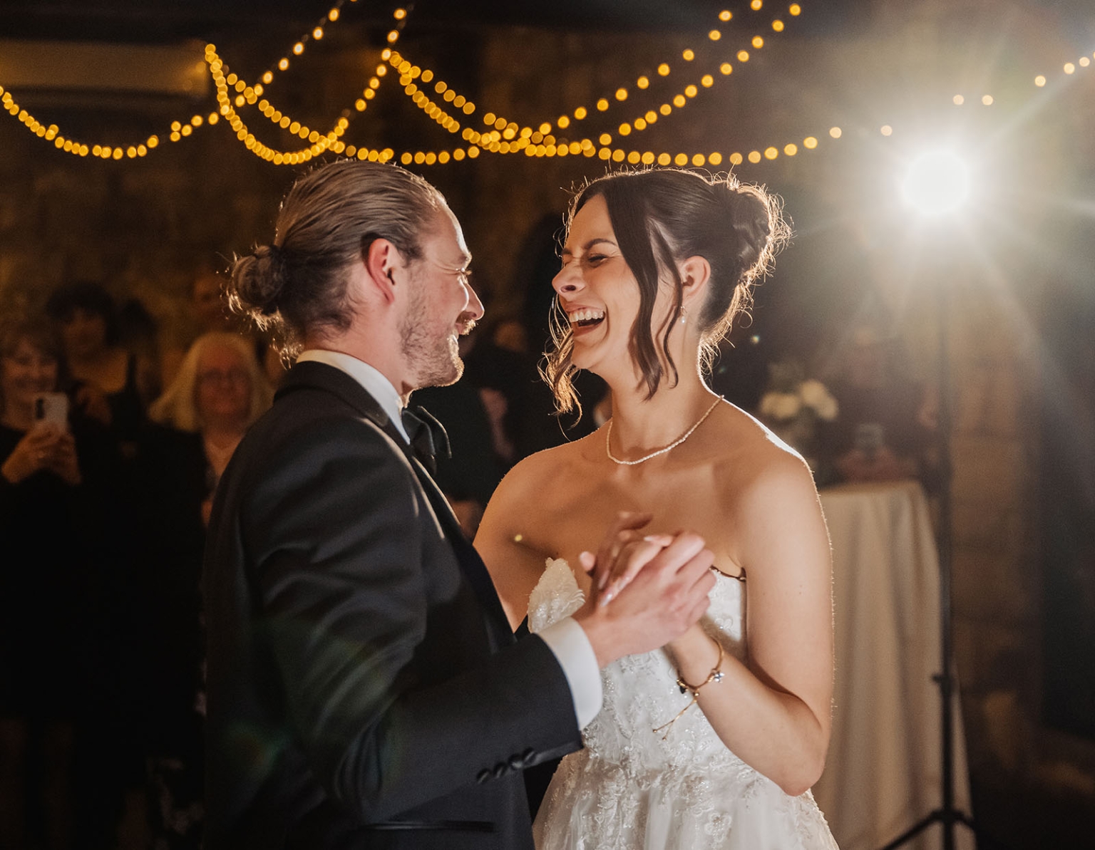 the manor wedding - crystal & mackenzie 94 Bride and groom dancing at warm wedding reception under fairy lights.