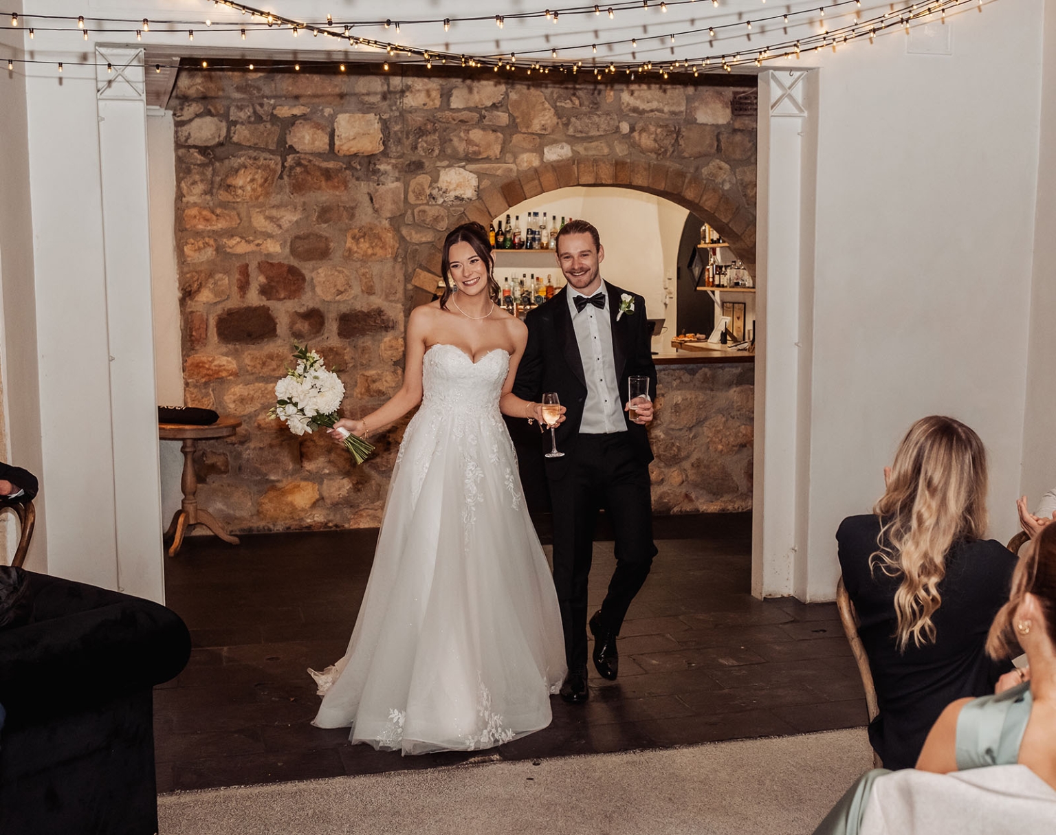 the manor wedding - crystal & mackenzie 87 Bride and groom make a joyful entrance at a rustic indoor wedding reception.