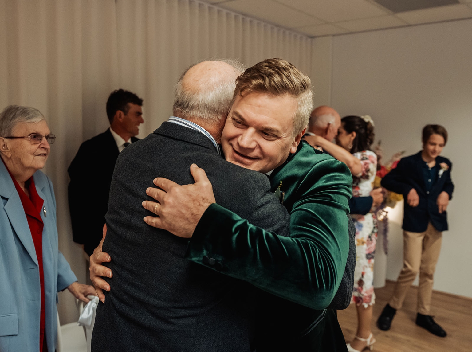 sa marriage office wedding – melissa & kyran 206 Emotional family hug at wedding reception with guests celebrating.