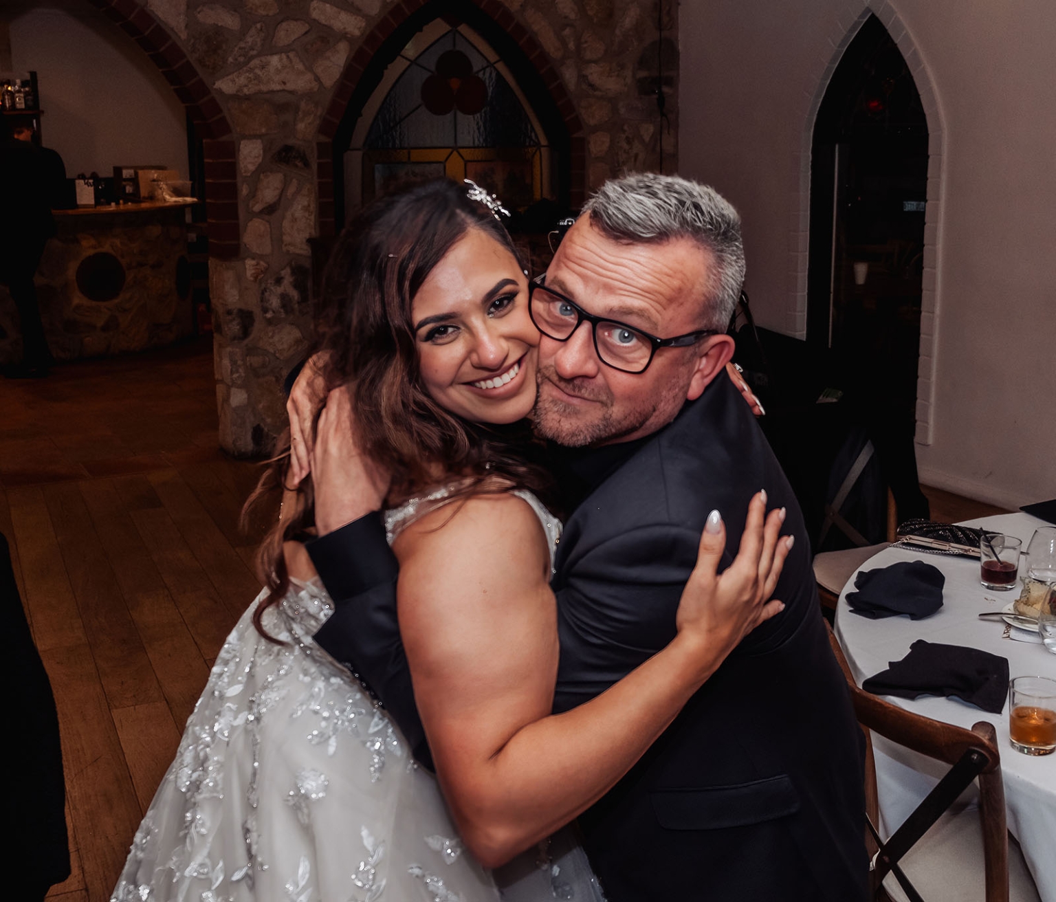 basket range wedding at the manor - leah & wes 80 Bride hugging guest at rustic wedding reception in historic stone venue.
